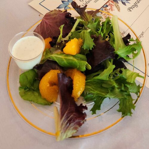 A salad with lettuce, mandarin oranges, and dressing.