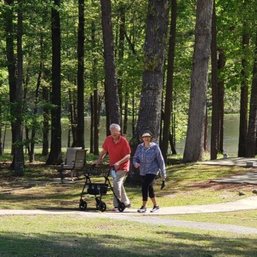 Residents enjoy a walk by the lake, an example of active Senior Living in Little Rock at Good Shepherd Community.