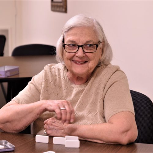 Senior woman with glasses playing dominoes