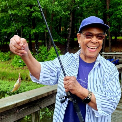 senior woman shows tiny fish she caught
