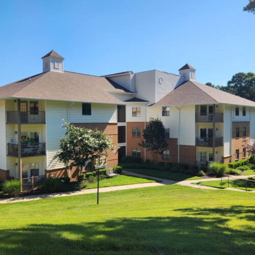 3-story apartment building with green lawn