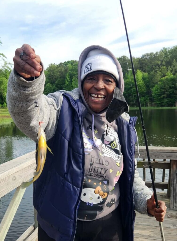 Happy resident catches fish at our independent living fishing derby at Good Shepherd Community.